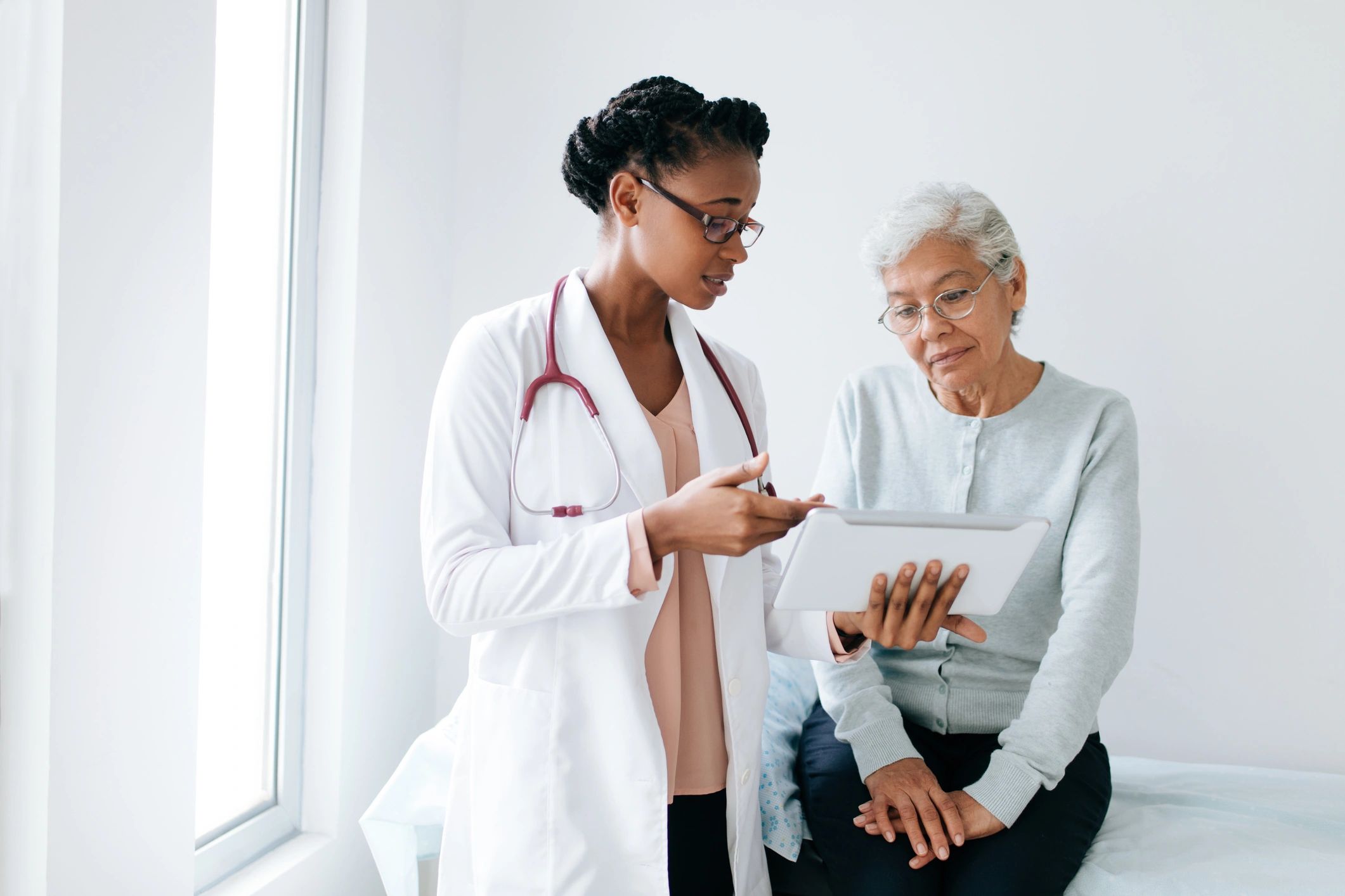 Doctor reviewing information with a patient on a tablet